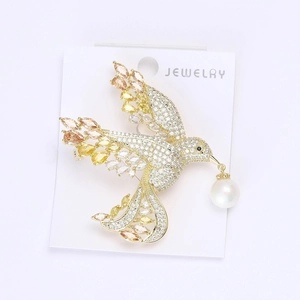 Macro detail of bird brooch featuring cubic zirconia inlay and a high-luster drop pearl