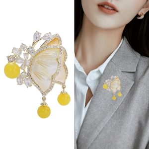 Elegant gold-plated butterfly brooch with white shell wings and yellow amber-like beads
