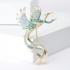 Macro shot of gradient blue enamel phoenix brooch with shimmering zircons on gold base