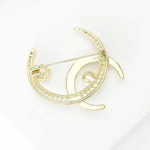 Elegant gold double crescent moon brooch with zircon crystals and polished finish