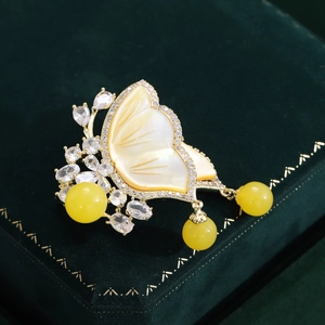 Detail of a gold butterfly brooch with mother of pearl wings and crystal accents