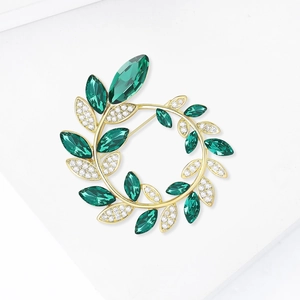 Vue détaillée de la broche couronne de laurier dorée avec cristaux verts taille marquise