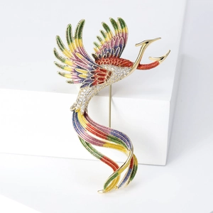 Detail of elegant phoenix brooch with colorful enamel wings and sparkling zircon inlay