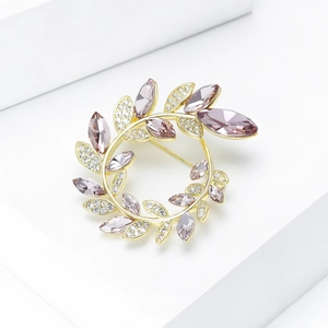 Détail de la broche feuille de luxe avec cristaux violets et zircons sur socle blanc