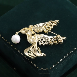 Macro detail of bird brooch back showing pin closure and honeycomb metal structure