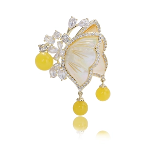 Elegant butterfly brooch with mother of pearl wings and dangling yellow amber beads
