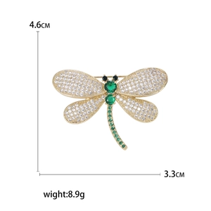 Exquisite gold-plated dragonfly brooch with white rhinestones and emerald gemstone accents