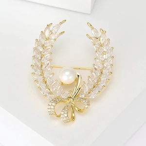 Vintage gold wheat ear brooch with large white pearl and zircon bow on display stand