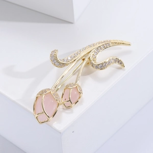 Luxurious pink tulip brooch with golden plating and sparkling crystals on white stone base