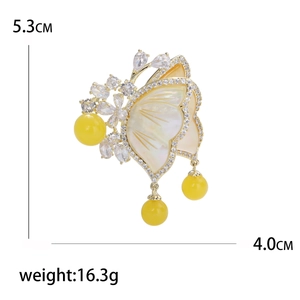 Elegant gold butterfly brooch with yellow shell wings and zircon crystals for suits