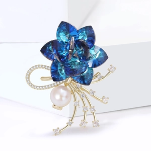 Spilla fiore placcata oro elegante con cristalli blu, perla bianca e dettagli in zircone