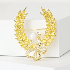Detail of wheat ear brooch with gold crystals, pearl center and a diamond bow