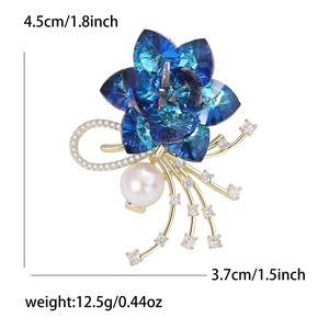 Elegante spilla a fiore in cristallo blu con base dorata e dettaglio perla bianca