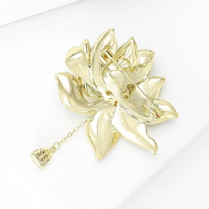 Elegant gold lotus brooch and pendant with intricate dangling bell on white background