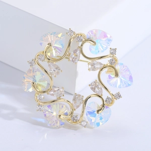 Makroaufnahme der goldenen Blumenkranz-Brosche mit Herzkristallen und glänzenden Zirkonia