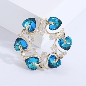 Eleganter Brosche mit blauen Herzkristallen und weißen Zirkonia auf Goldbasis