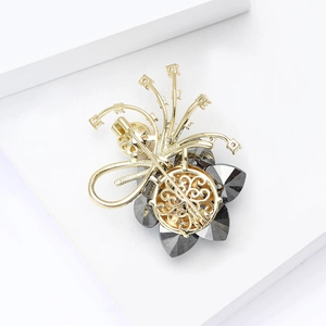 Elegante spilla a fiore dorata con micro-zirconi e petali di cristallo grigio scuro