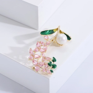 Détail de la broche orchidée avec pétales en cristal rose, feuilles d'émail et une grande perle
