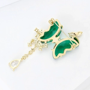Detailed back view of a butterfly brooch showing the pin clasp and golden tassel chain