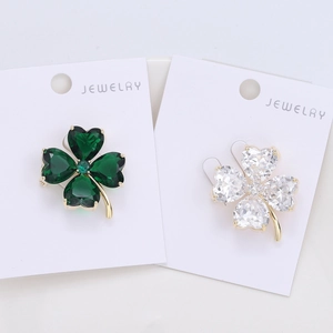 Détail de broches trèfle en cristal en forme de cœur, couleurs verte et blanche
