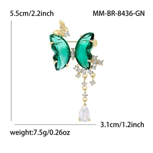 Elegant green crystal butterfly brooch with gold plating and teardrop pendant on white background