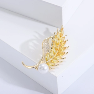 Elegant gold wheat brooch with yellow crystals and pearl on white geometric stairs