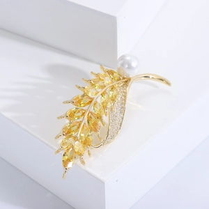 Detail of wheat ear brooch with yellow marquise gems and a white pearl on golden base