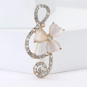 Elegant treble clef brooch with rhinestones and opal heart stones on gold base