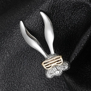 Detail of a rabbit brooch with silver metal, sparkling crystals, and golden sunglasses