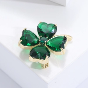 Vue macro détaillée de la broche trèfle à quatre feuilles avec cristaux verts en cœur