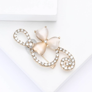 Detail of clover brooch with pink heart-shaped opals and white crystals on gold base