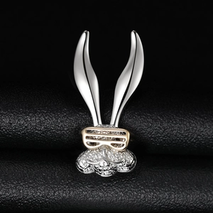 Macro view of crystal pavé rabbit ring with golden glasses on premium black leather