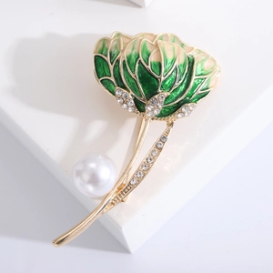 Detail of flower brooch with green enamel petals, sparkling rhinestones and a white pearl