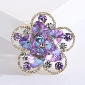 Broche fleurie élégante avec cristaux violets et bleus sur base dorée pour vestes