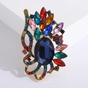 Gros plan détaillé d'une broche vintage avec une pierre bleue et des cristaux colorés