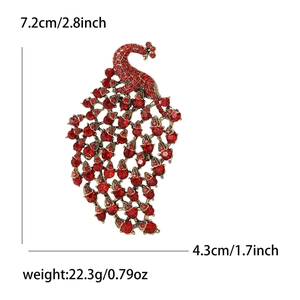 Vintage peacock brooch in gold alloy with red rhinestones, size 7.2cm by 4.3cm shown on white