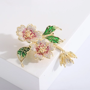 Detail view of flower brooch with pink zircons, enamel leaves and a white pearl