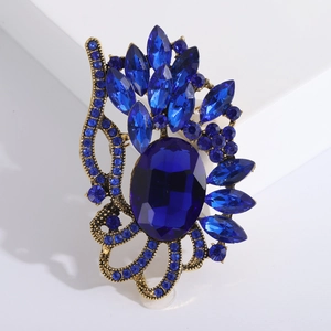 Broche vintage avec grand cristal bleu ovale et pierres marquises sur alliage doré