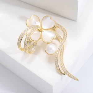 Détail macro d'une broche fleur dorée avec pétales en nacre et pavé de zircons