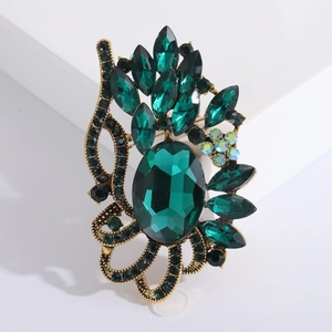 Détail d'une broche vintage en or avec pierre vert foncé et cristaux marquises