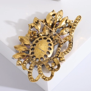 Vue détaillée du dos de la broche dorée avec des motifs complexes en métal évidé
