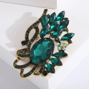 Broche vintage dorée avec cristaux vert émeraude au design floral raffiné de vignes