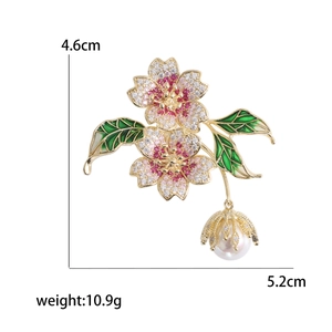 Broche fleur de cerisier élégante avec zircons roses, émail vert et perle d'eau douce fine