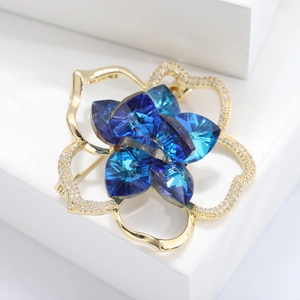 Detail of camellia brooch with dark blue crystals and cubic zirconia in gold plating