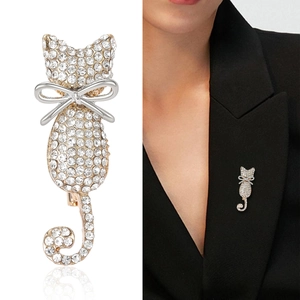 Elegant cat brooch with sparkling rhinestones and silver bow on gold-plated metal base