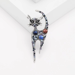 Macro shot of silver cat brooch featuring purple crystals and deep blue gemstones