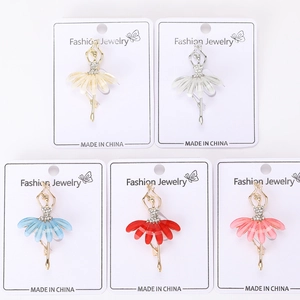 Détail de cinq broches ballerines colorées avec strass brillants sur cartes bijoux