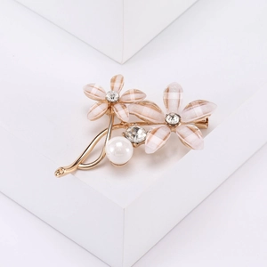 Vue détaillée de la broche fleur rayée rose et blanc avec des perles et des strass brillants