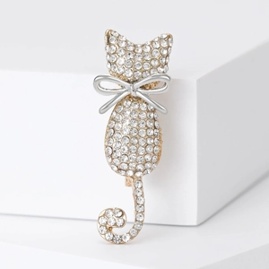 Elegant cat brooch featuring sparkling crystals and silver bow on white geometric stand