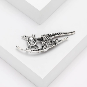 Close-up of vintage silver cat brooch with embossed texture and secure pin clasp back